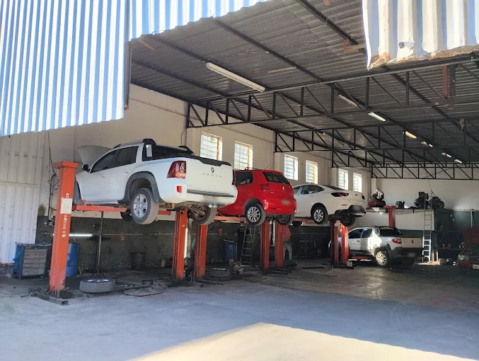 Veículos em elevadores na oficina para inspeção de freios e suspensão